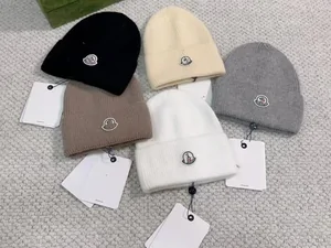Knitted beanies in cream, white and grey on a table