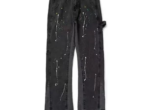 Black jeans with paint flecks hanging against a white wall